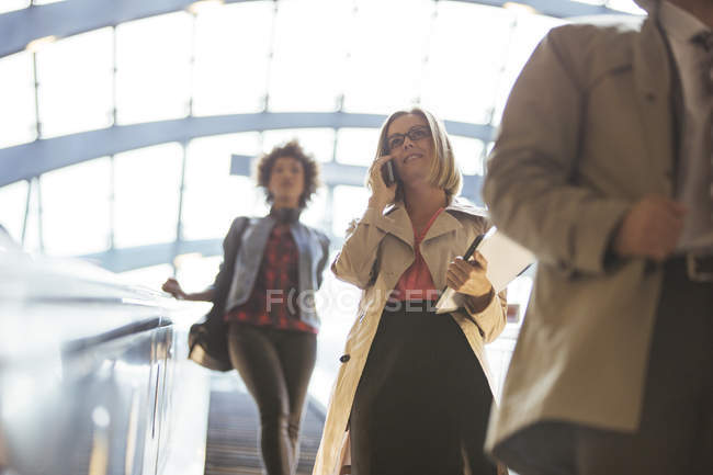 Low angle view of business people riding escalator — Stock Photo