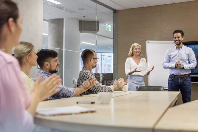 Business people clapping for businessman in conference room meeting — Stock Photo