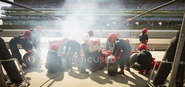 Екіпаж ями замінив шини на формулі одного гоночного автомобіля на піт-лейні — стокове фото
