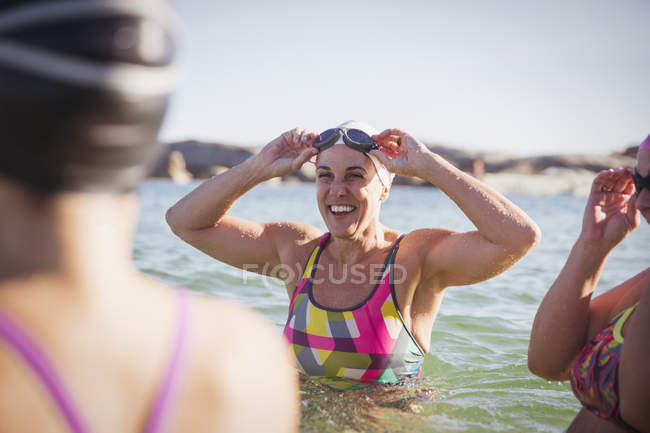 Sonriendo Mujeres nadadoras activas en el océano al aire libre - foto de stock