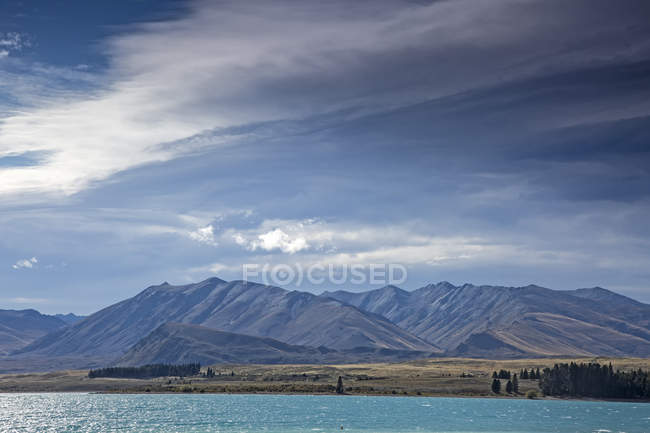 Montanhas além do lago ensolarado, Lago Tekapo, Ilha do Sul, Nova Zelândia — Fotografia de Stock