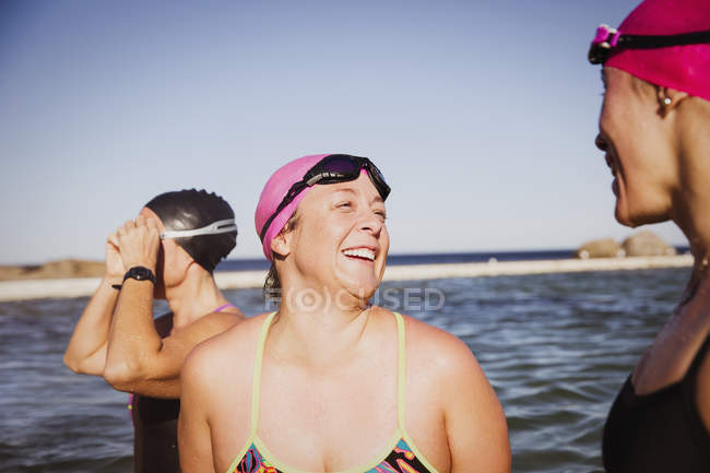 Mulheres nadadoras ativas sorridentes no oceano ao ar livre — Fotografia de Stock