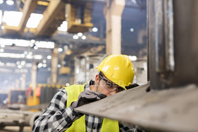 Lavoratore siderurgico che esamina l'acciaio in fabbrica, primo piano — Foto stock