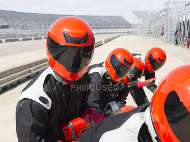 Boxencrew trägt Helm in sonniger Boxengasse — Stockfoto