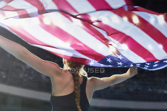 Atleta femenina corriendo vuelta de victoria con bandera americana - foto de stock