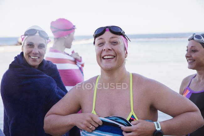Sorridente Nuotatori attivi femminili con asciugamani in mare aperto — Foto stock