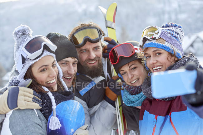 Усміхнені друзі на лижах беруть селфі з телефоном — стокове фото