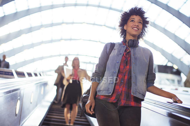 Mujer montando escaleras mecánicas en metro - foto de stock