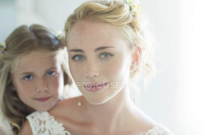 Portrait of bride and bridesmaid looking at camera — Stock Photo
