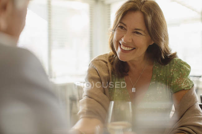 Усміхнена зріла жінка насолоджується побаченням, обідає в ресторані — стокове фото