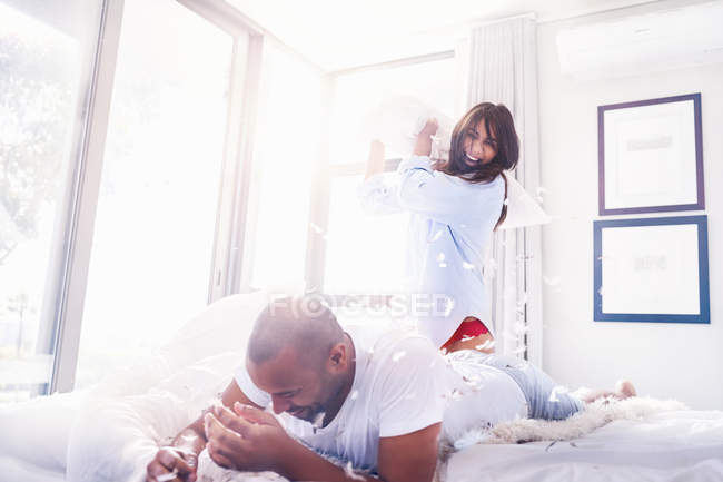 Brincalhão casal travesseiro lutando no quarto — Fotografia de Stock