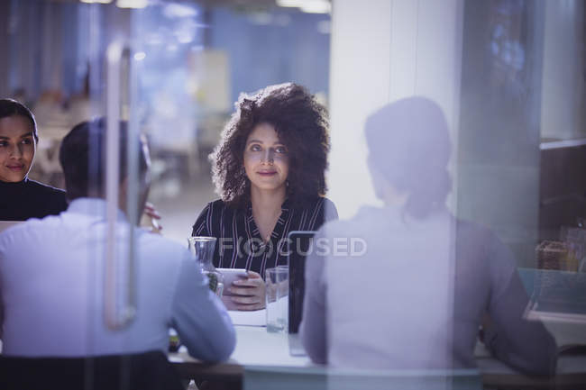 Femme d'affaires à l'écoute dans la salle de conférence sombre réunion — Photo de stock
