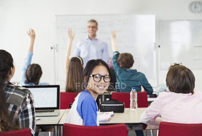 Portrait smiling girl student sitting in classroom during lesson — Stock Photo