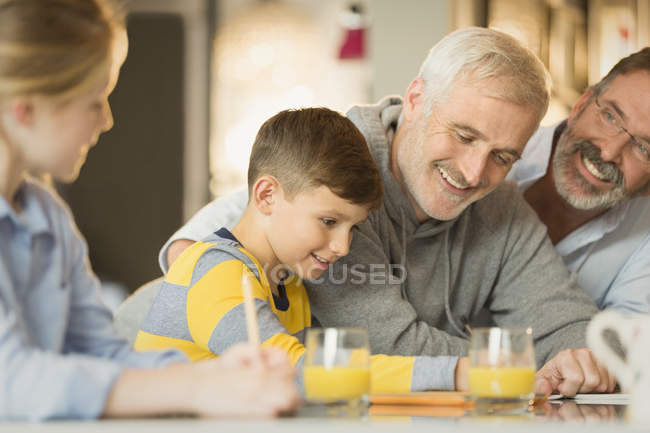 Male gay parents and children using digital tablet — Stock Photo