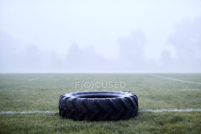 Резиновая шина на туманном футбольном поле — стоковое фото