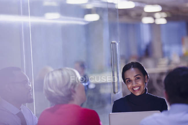 Smiling businesswoman using laptop in conference room meeting — Stock Photo