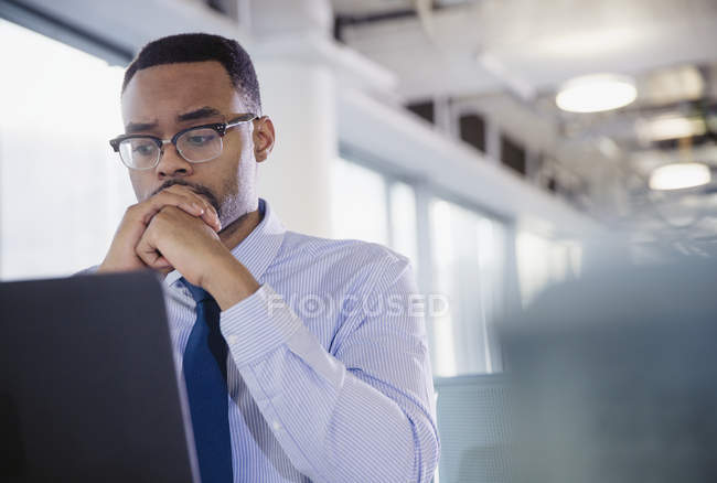 Serious, worried businessman working at laptop in office — Stock Photo