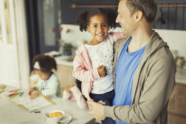 Porträt lächelnder multiethnischer Vater und Tochter in der Küche — Stockfoto