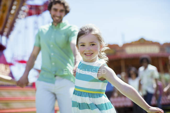 Menina puxando seu pai no parque de diversões — Fotografia de Stock