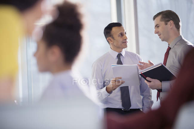 Dois empresários falando na janela do escritório — Fotografia de Stock