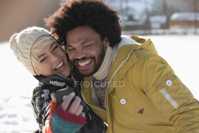 Casal feliz tomando selfie na neve — Fotografia de Stock