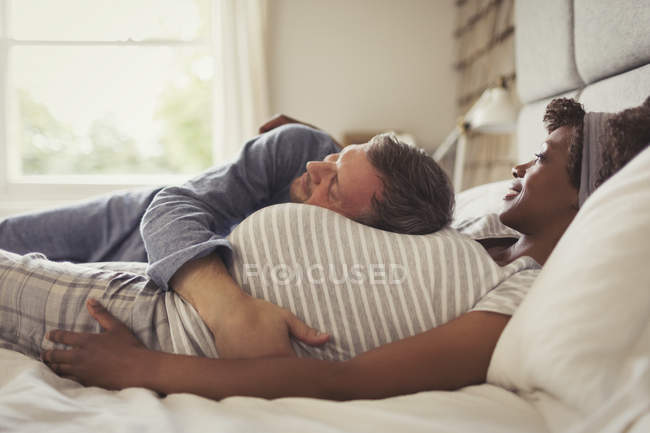 Mann kuschelt schwangere Frau auf Bett — Stockfoto