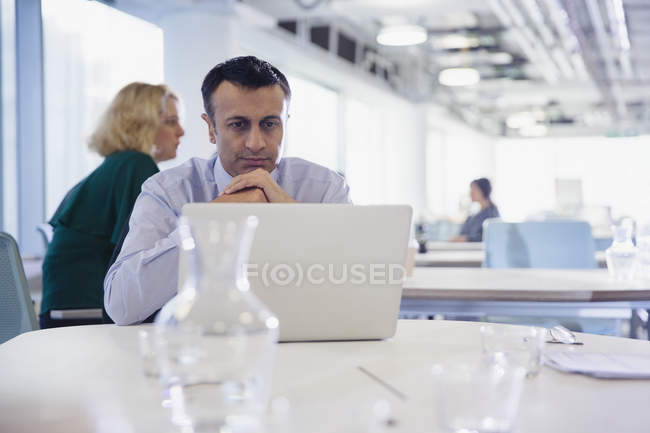 Focado, homem de negócios sério trabalhando no laptop no escritório — Fotografia de Stock