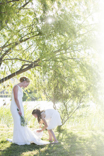 Braut und Brautjungfer stehen während des Hochzeitsempfangs im heimischen Garten — Stockfoto