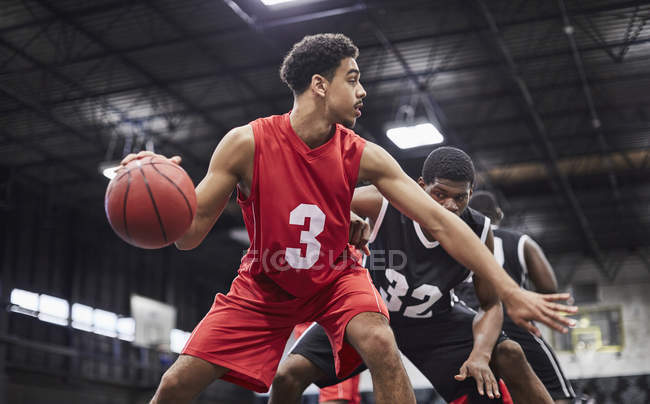 Junge männliche Basketballspieler dribbeln den Ball, spielen Spiel in der Turnhalle — Stockfoto