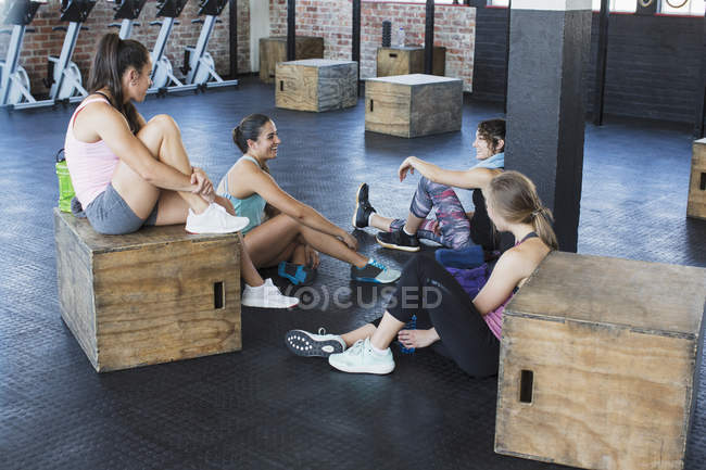 Молоді жінки розмовляють і відпочивають пост тренування в спортзалі — стокове фото
