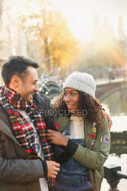 Affettuosa coppia che si abbraccia lungo il canale autunnale — Foto stock