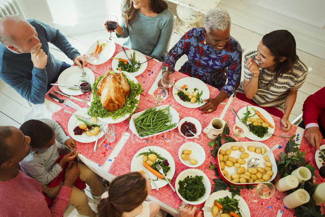 Vista aérea familia multi-étnica multi-generación disfrutando de la cena de Navidad en la mesa - foto de stock