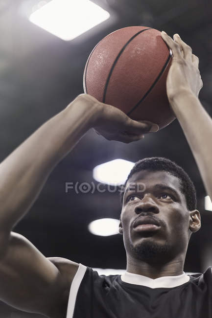 Enfocado joven jugador de baloncesto masculino tiro libre - foto de stock