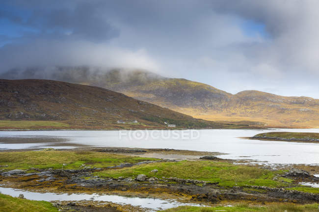 Tranquil scene clouds over rolling hills and lake, Loch Aineort, South Uist, Outer Hebrides — Stock Photo