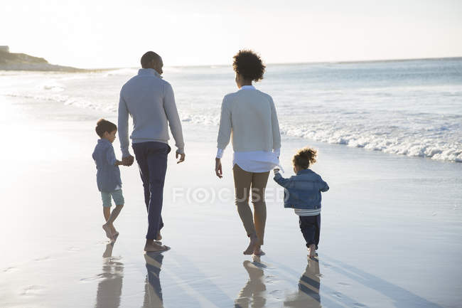 Familia feliz divirtiéndose en la playa - foto de stock