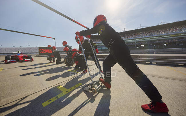 Pit crew preparing for formula one race car pit stop in pit lane — Stock Photo