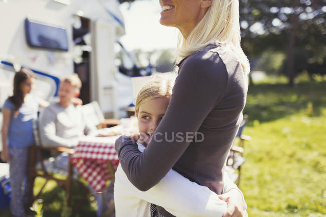 Мати і дочка обіймаються біля сонячного мото дому — стокове фото