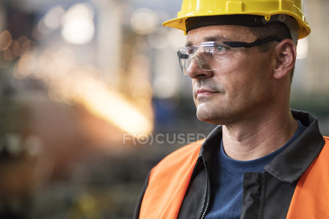Крупним планом стомлений сталевий працівник дивиться геть — стокове фото