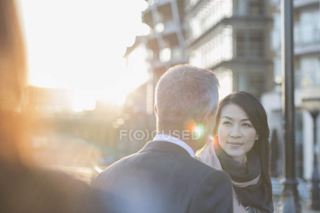Businesswoman listening to businessman on urban street — Stock Photo