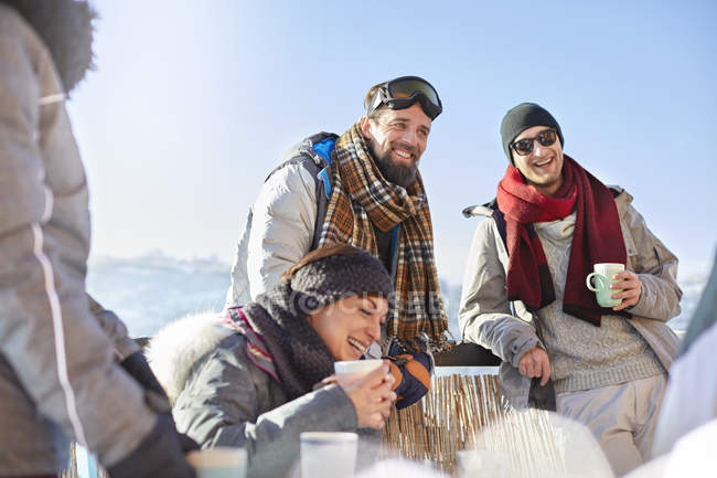 Усміхнені друзі на лижах п'ють каву і гаряче какао за межами міста — стокове фото