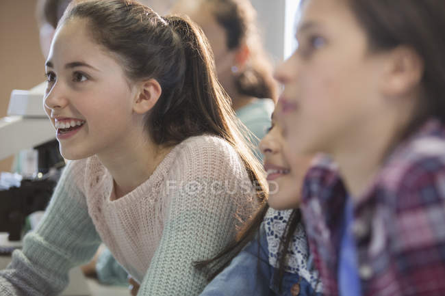 Neugierige, lächelnde Studentinnen, die im Hörsaal zuhören — Stockfoto