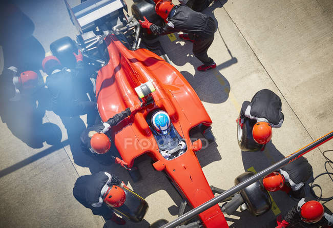 Екіпаж над піт-стопом працює над формулою одного гоночного автомобіля на піт-стопі — стокове фото