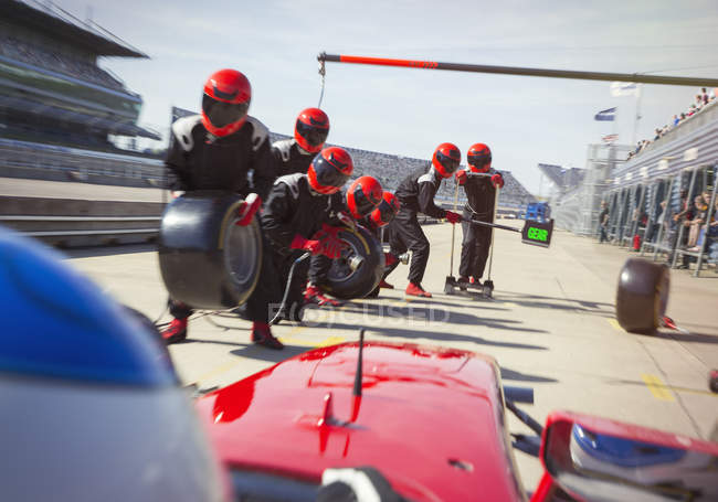 Tripulação de poço com pneus prontos para se aproximar de fórmula um carro de corrida em pit lane — Fotografia de Stock