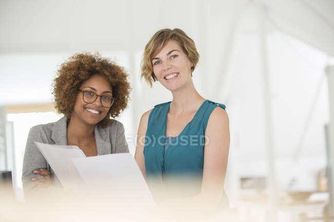Retrato de dos trabajadores de oficina sonrientes en la oficina moderna - foto de stock
