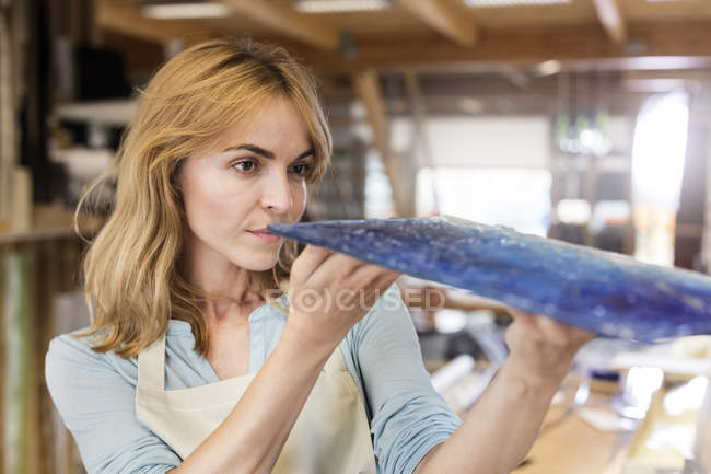 Artist examining stained glass in studio — Stock Photo