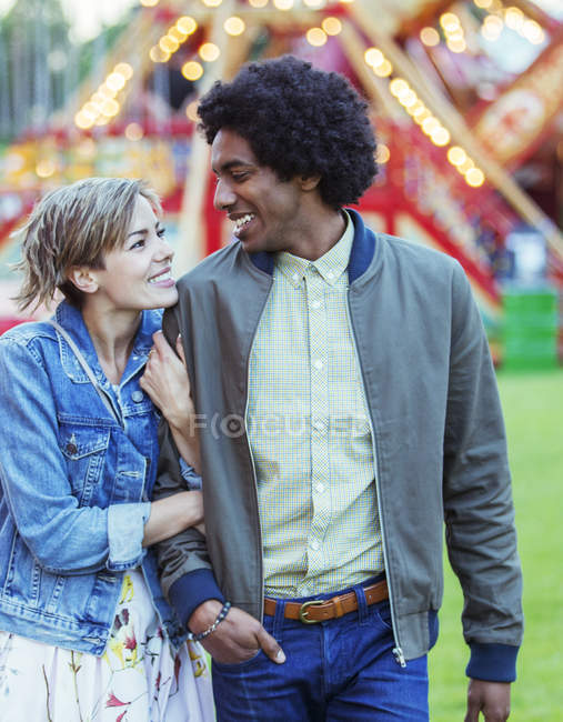 Junges multiethnisches Paar lächelt einander im Freizeitpark zu — Stockfoto