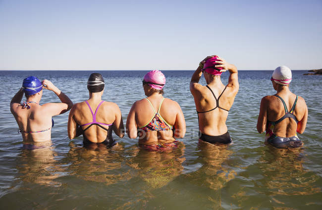 Vista trasera de nadadoras activas femeninas en el mar al aire libre - foto de stock