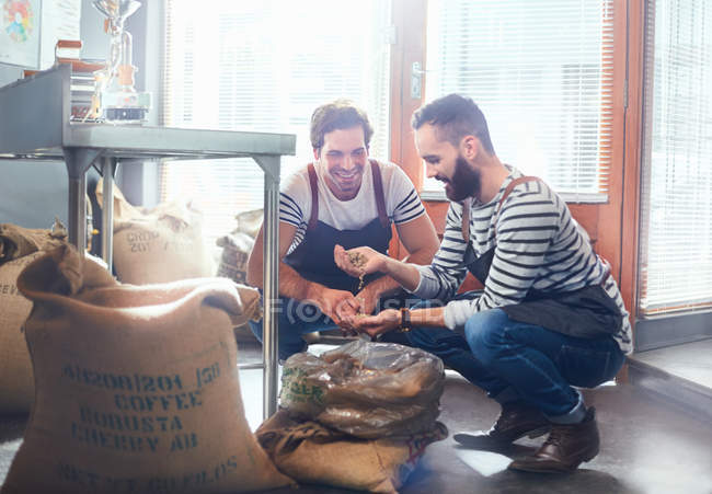 Torrefattori maschi che esaminano chicchi di caffè — Foto stock