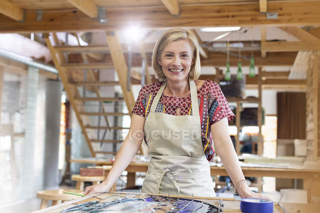 Retrato sorrindo artista vitral trabalhando em estúdio — Fotografia de Stock
