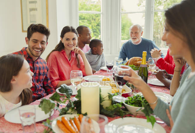 Familia multiétnica multigeneracional disfrutando de la cena de Navidad en la mesa - foto de stock